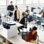 Un gruppo di professionisti che collaborano in ufficio, utilizzando computer e la stampante multifunzione Xerox® VersaLink® B625 per i loro compiti. Un gruppo di professionisti che collaborano in ufficio, utilizzando computer e la stampante multifunzione Xerox® VersaLink® B625 per i loro compiti.